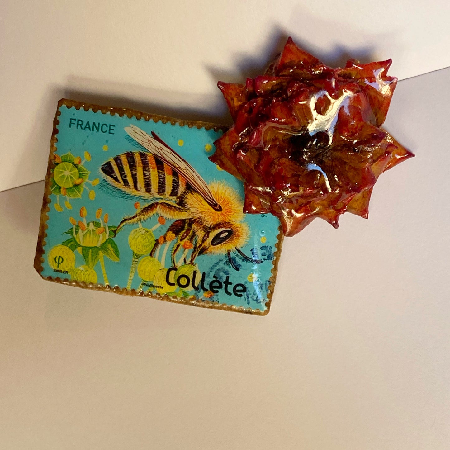 Mini rose brooch and bee postage stamp.